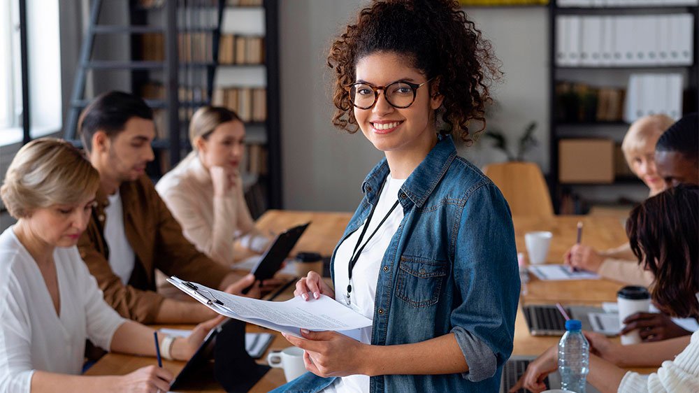 Mulher empreendedora em sala de reunião com equipe